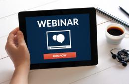 Hand holding an iPad that says Webinar Join Now